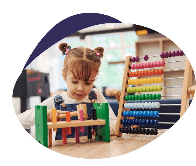 Child playing with an abacus and a wooden hammer bench during a screening session